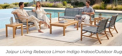 Three people lounge on woven outdoor sofas arranged over a large off-white rug by a pool. Image Text: Jaipur Living Rebecca Limon Indigo Indoor/Outdoor Rug