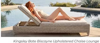 Woman reclining on a woven outdoor chaise lounge beside an infinity pool with scenic coastal ocean views beyond.