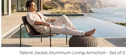 Man relaxing in a woven outdoor lounge chair with matching ottoman beside an infinity pool overlooking the coastline.
