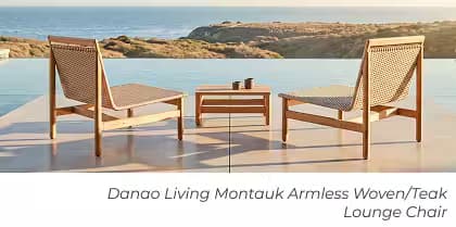 Two woven teak lounge chairs with a matching side table beside an infinity pool overlooking the ocean.